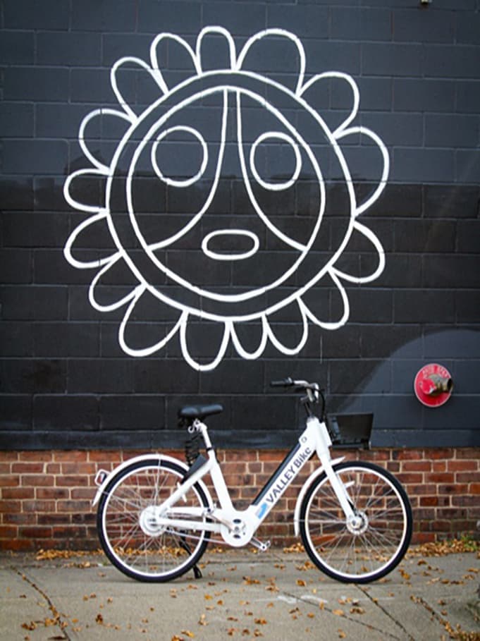 White Butterfly bike parked in front of a mural